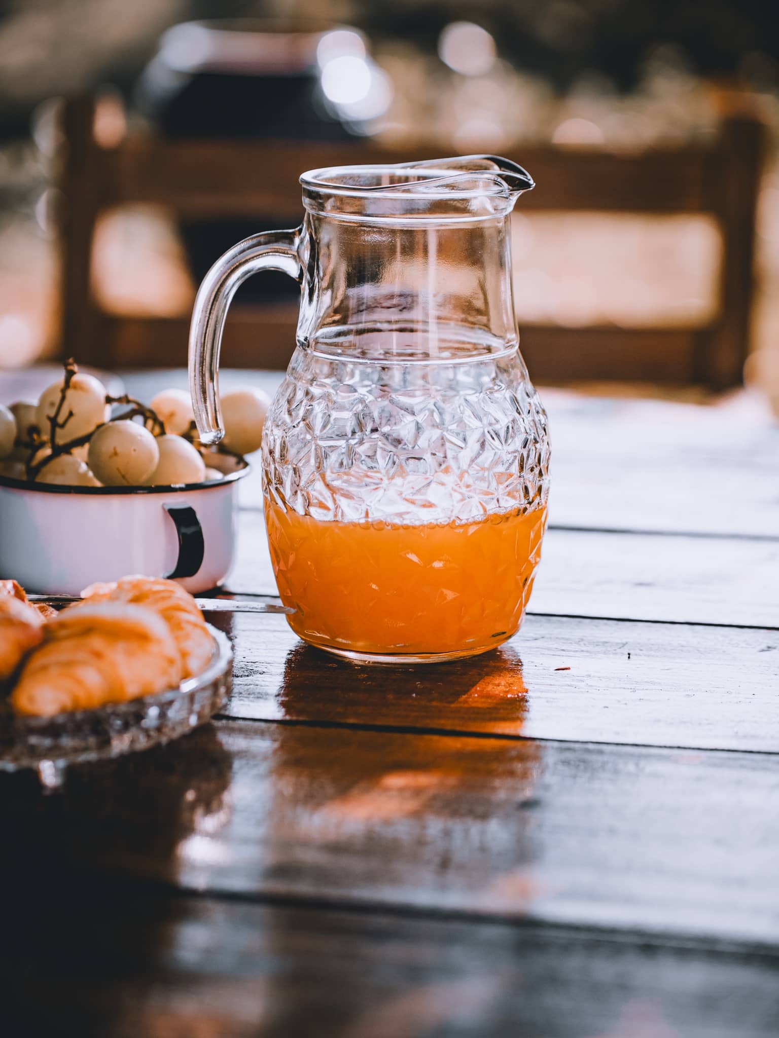 Jarra de suco de laranja e pães no café colonial